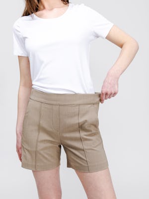 model wearing womens velocity tailored short flax and womens luxe touch tee white pulling on waistband