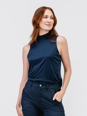model wearing womens luxe touch mock neck navy and womens kinetic twill 5 pocket pant steel blue heather full body one hand in pocket