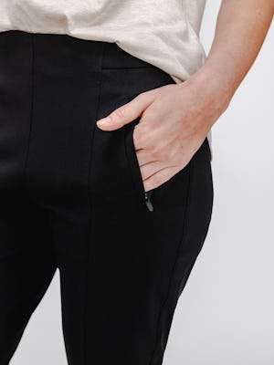 Close up of zippered pocket on Black Women's Kinetic Pintuck pant on model with hand in pocket