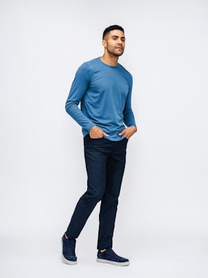 Men's Atlantic Blue Composite Merino Long Sleeve Tee and Steel Blue Heather Kinetic Twill 5-Pocket Pant on model walking right with hands in pockets
