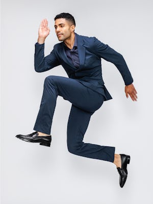 Men's Azurite Heather Velocity Suit Jacket on model jumping in air