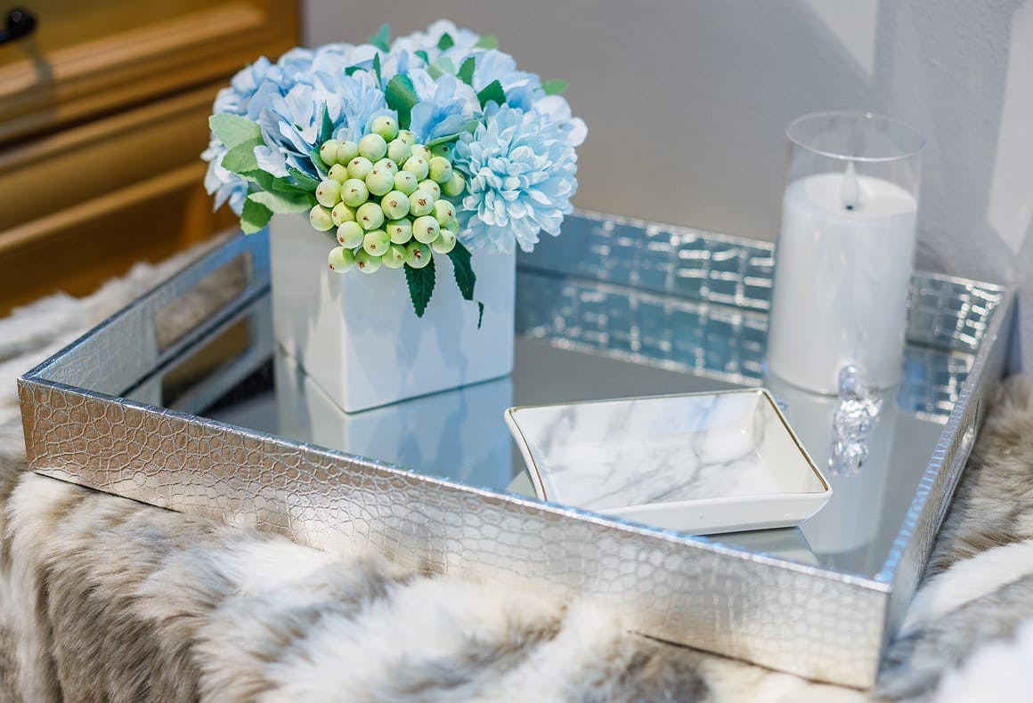 tray with flowers, candle, and marble plate on it