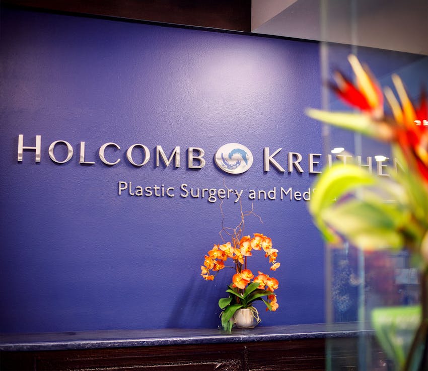 Holcomb plastic surgery logo on a wall