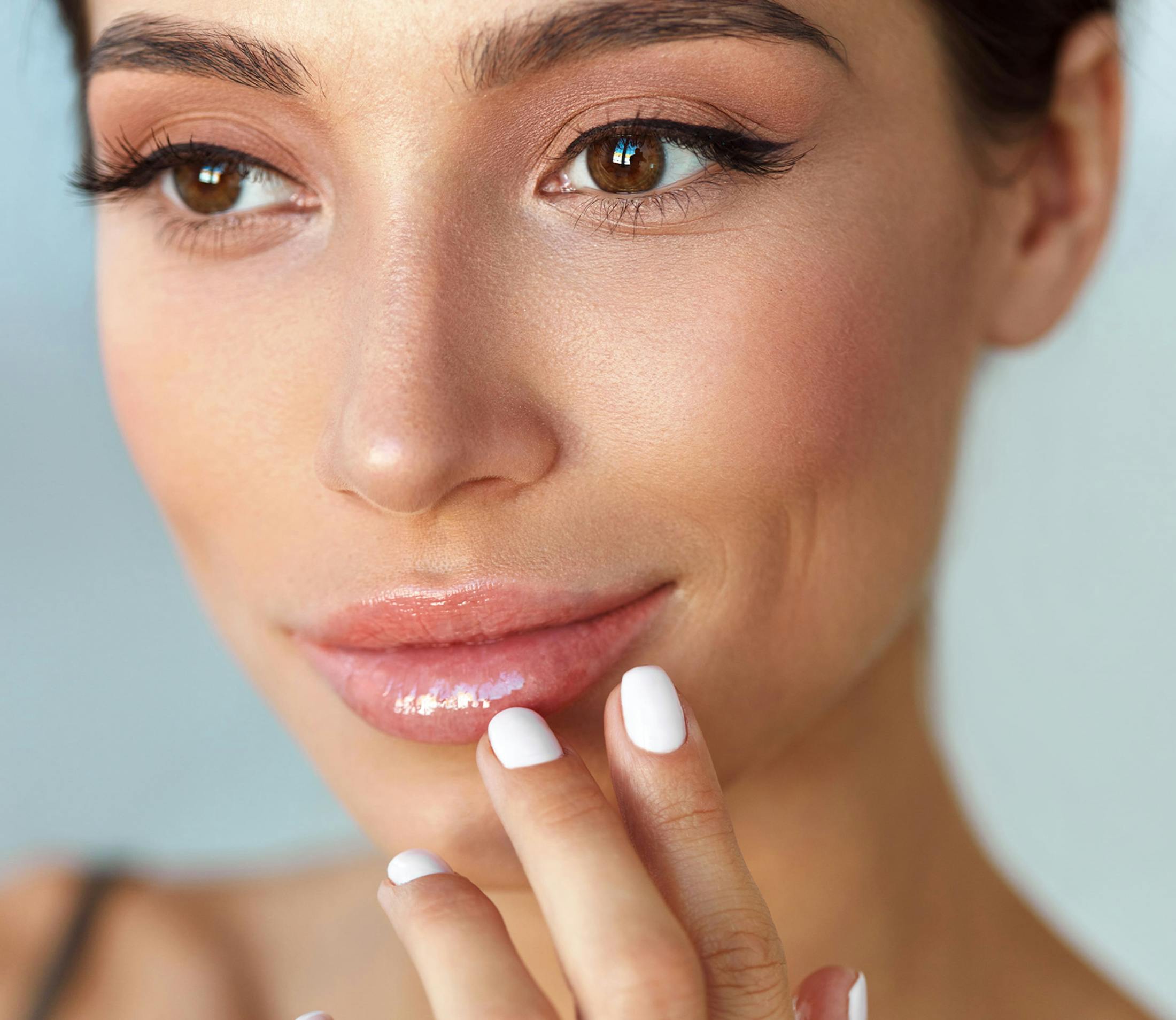 woman smiling while touching her bottom lip
