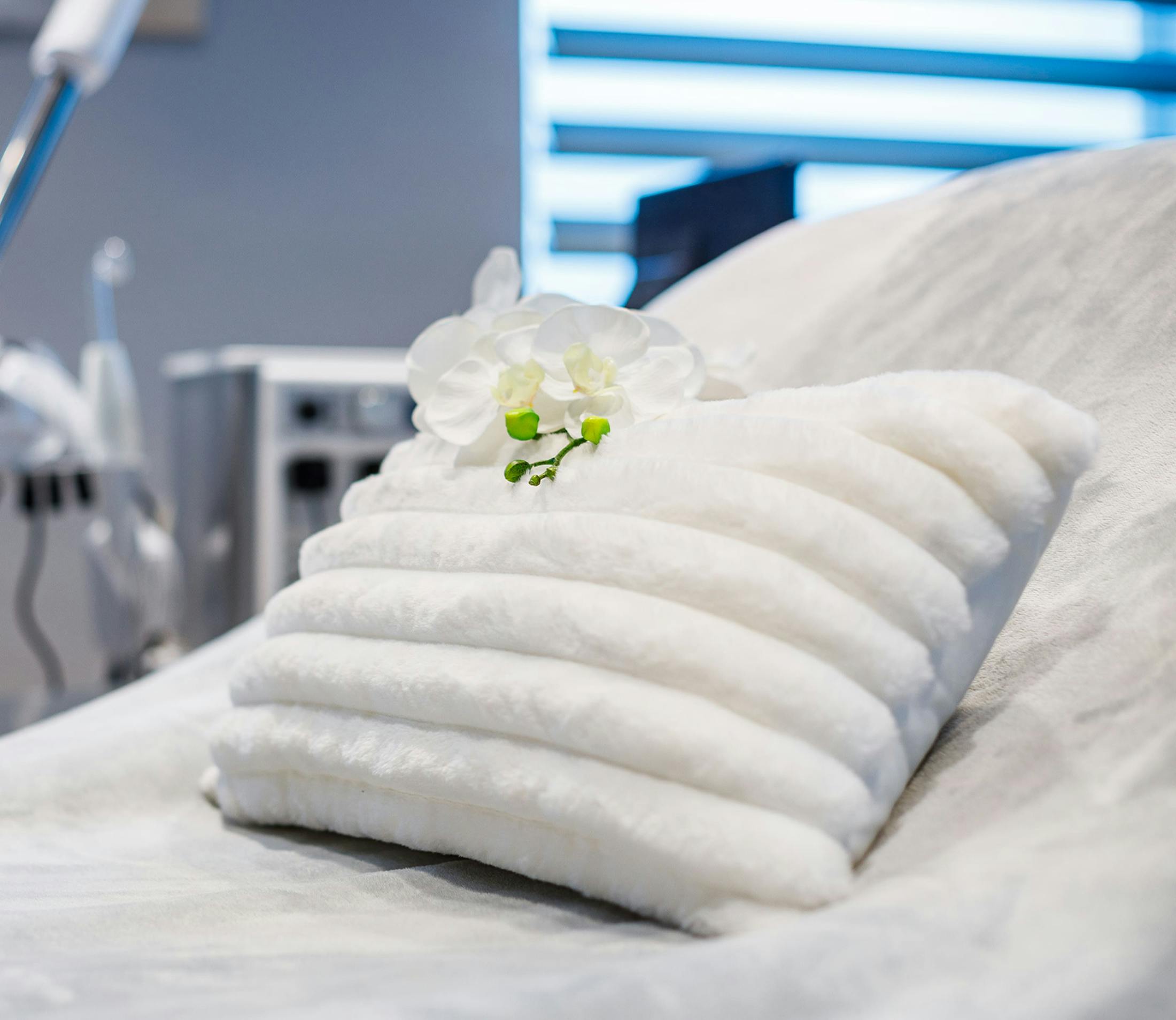 white pillow on plush white blanket