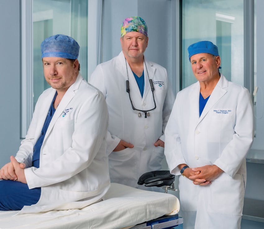 Dr. Kreithen, Dr. Holcomb, and Dr. Salzman standing in medical attire