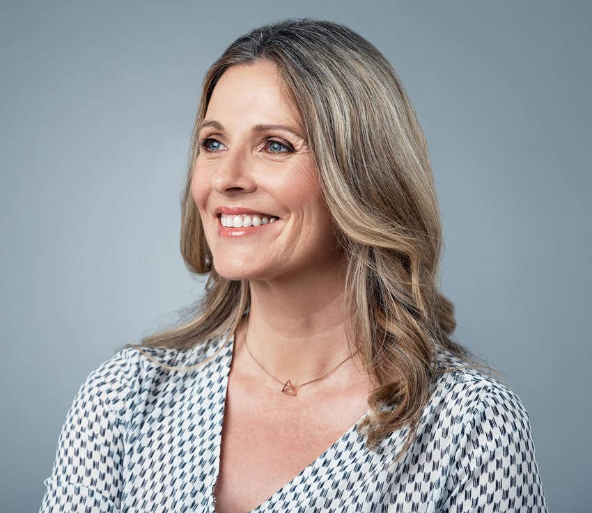 woman in white and black patterned shirt smiling
