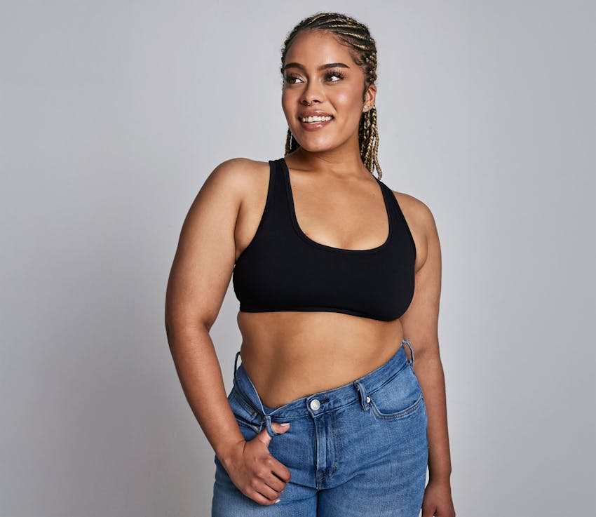 woman in black bra with her hand in her jeans belt loop