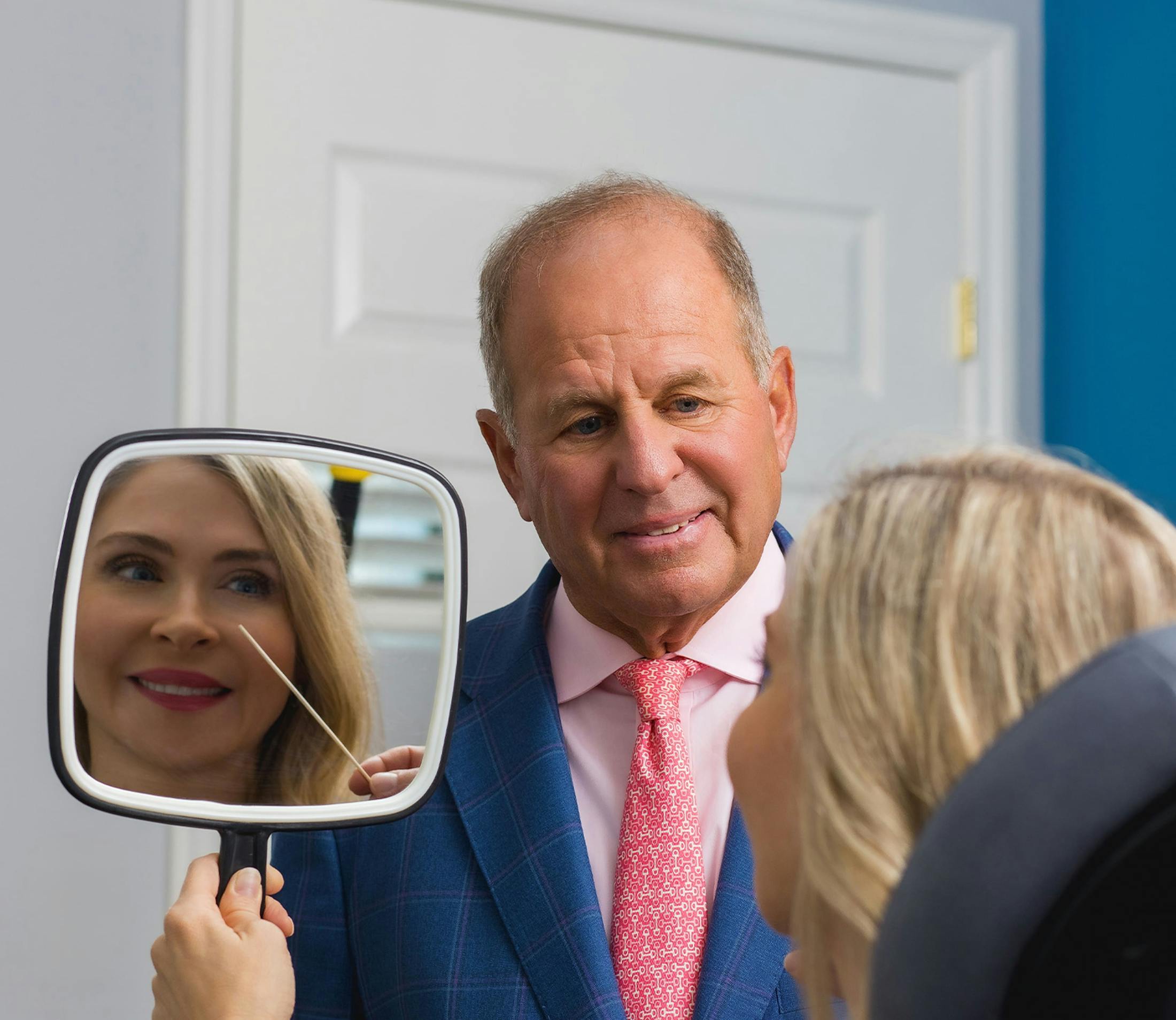 Dr. Salzman with patient as she looks into handheld mirror