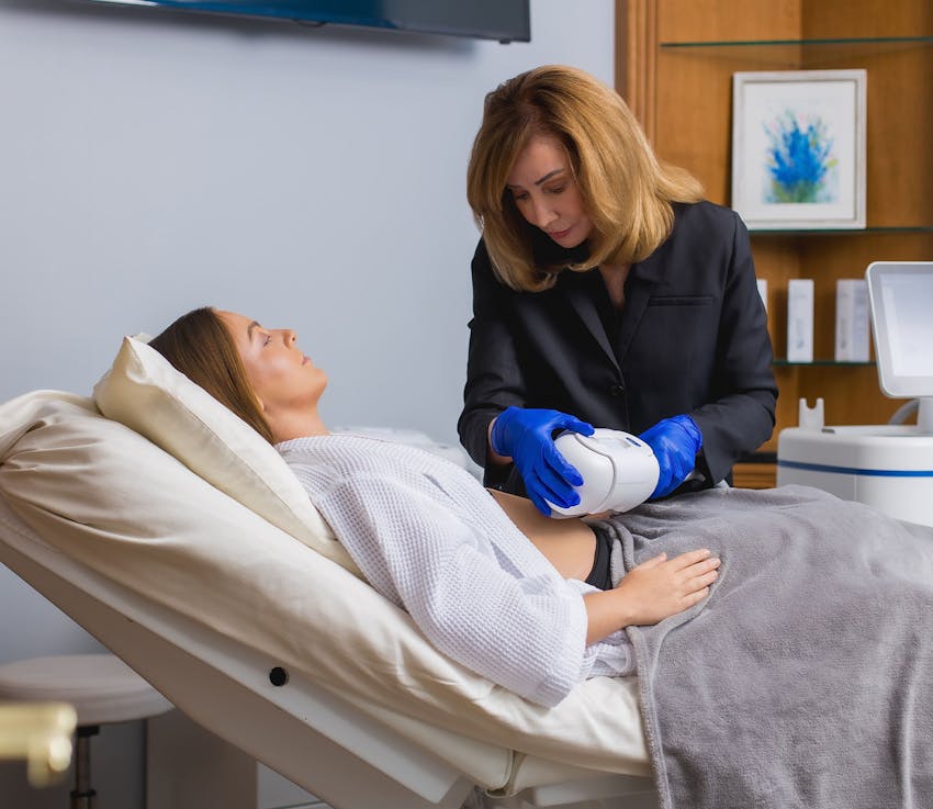 medical personnel applying CoolSculpting machine to patients stomach
