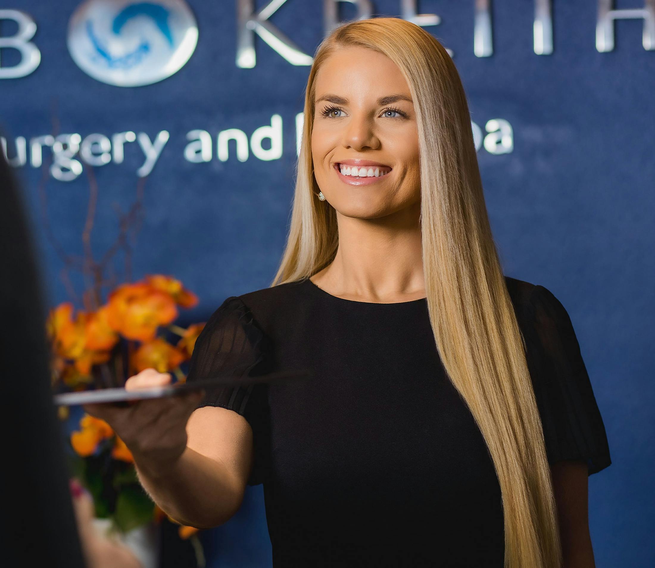 woman in Holcomb & Kreithen lobby handing a device to someone