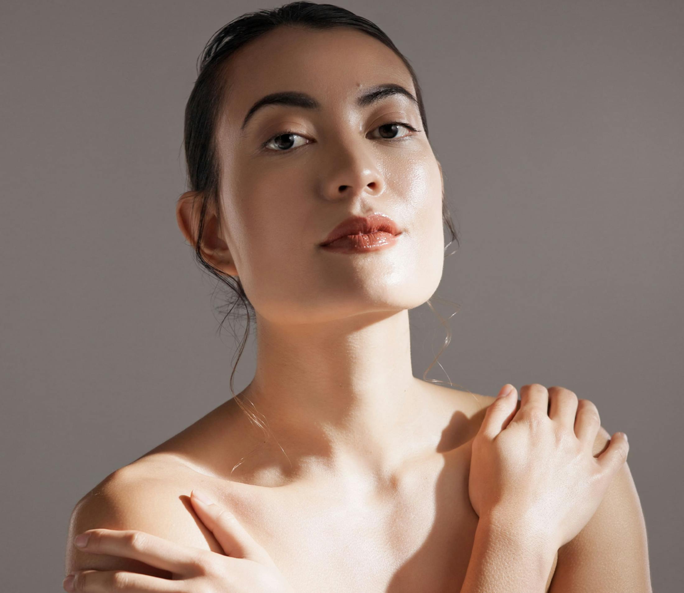 woman hugs shoulders with sunlight on her face