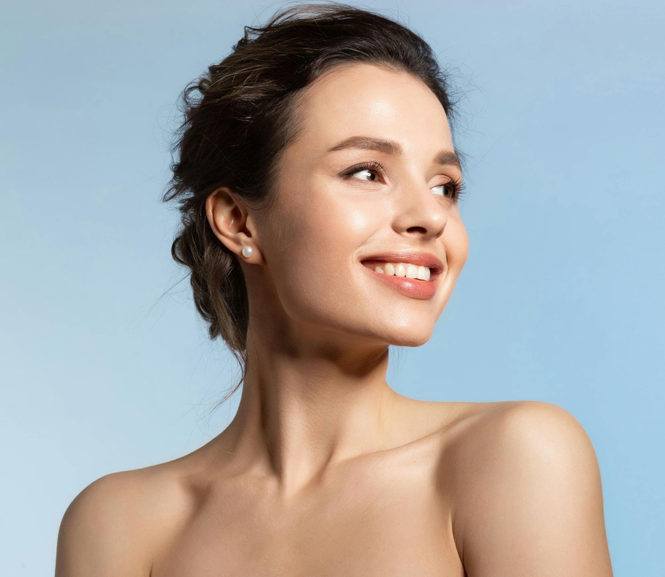 woman smiles looking over her shoulder with hair in bun