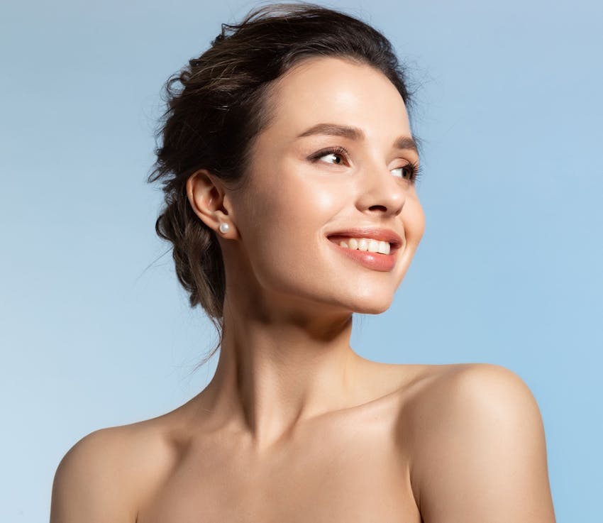 woman smiles looking over her shoulder with hair in bun