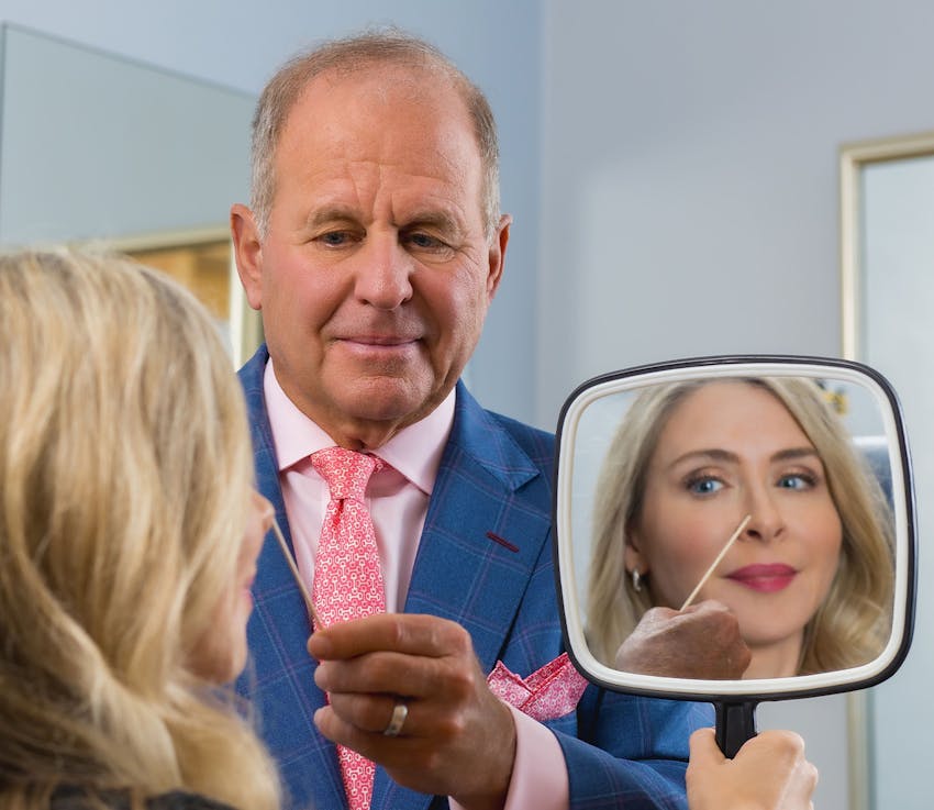 doctor looking at female patient's nose