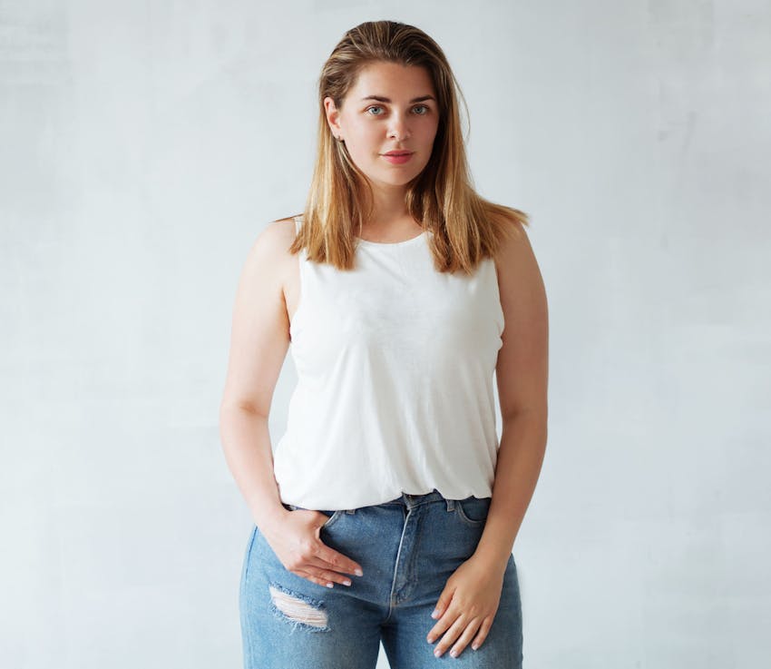 woman in white tanktop and jeans