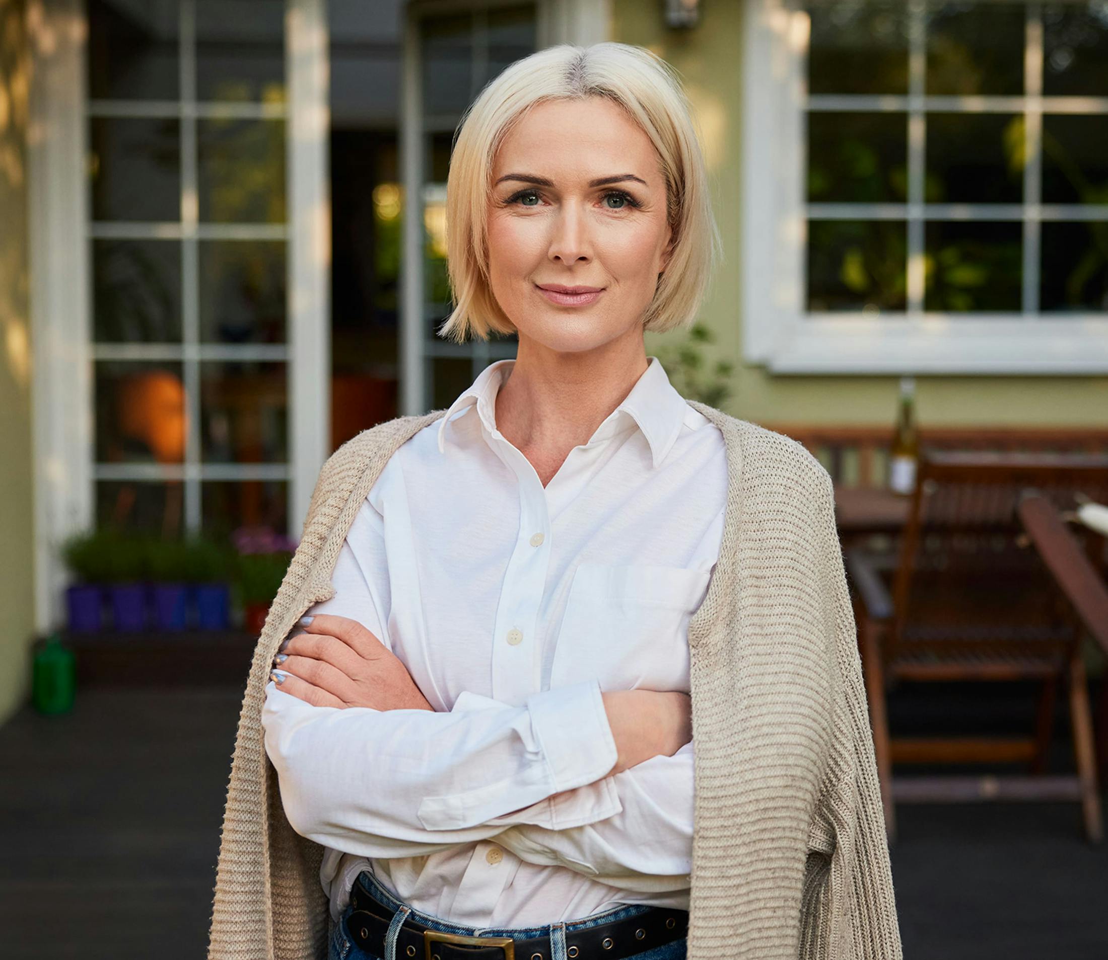 woman outside with her arms crossed and her sweater laying on her shoulders