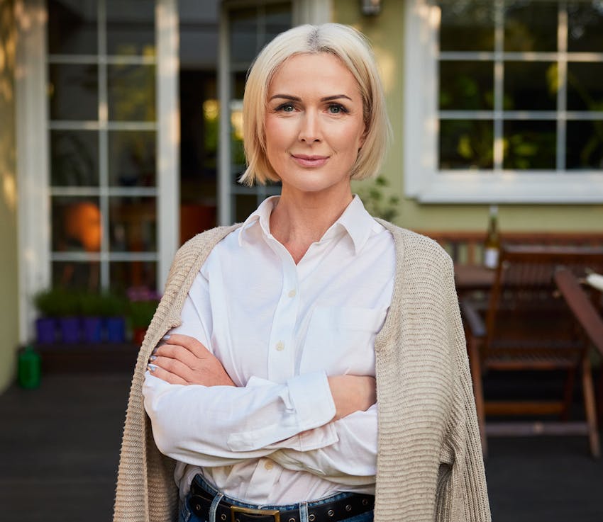 woman outside with her arms crossed and her sweater laying on her shoulders