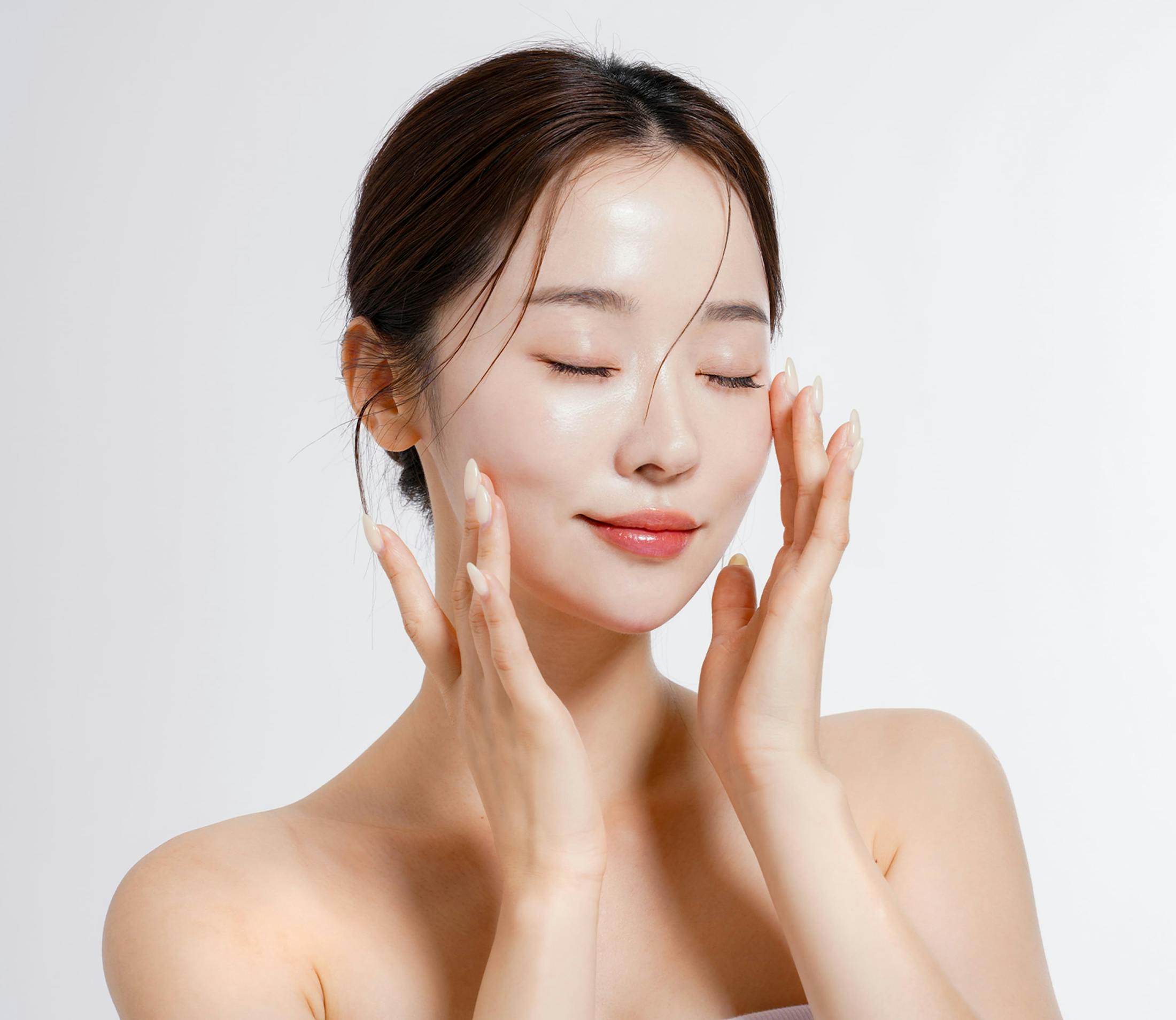 woman touches her cheek and temple with her eyes closed