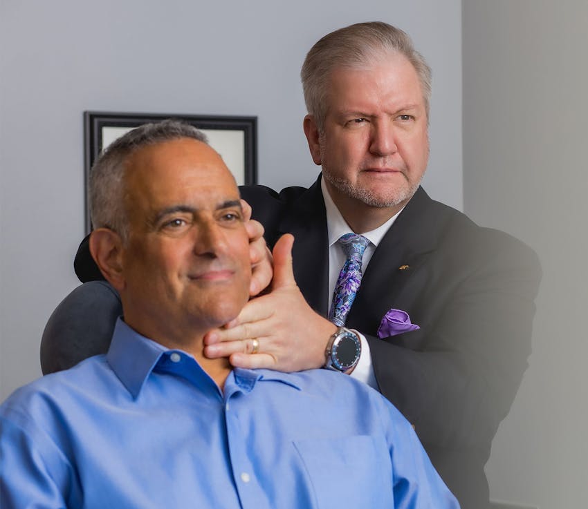 doctor with male patient checking his neck contour