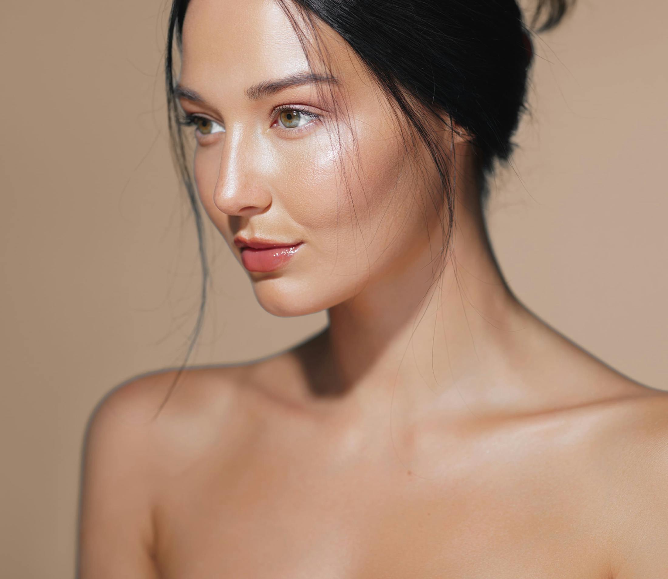 woman looks forward with dark hair in a bun