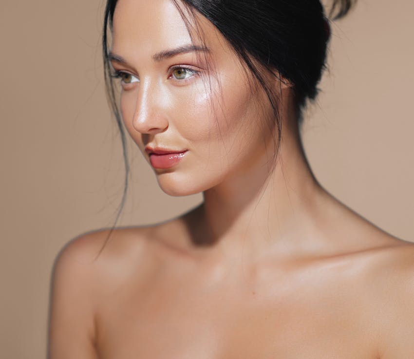 woman looks forward with dark hair in a bun