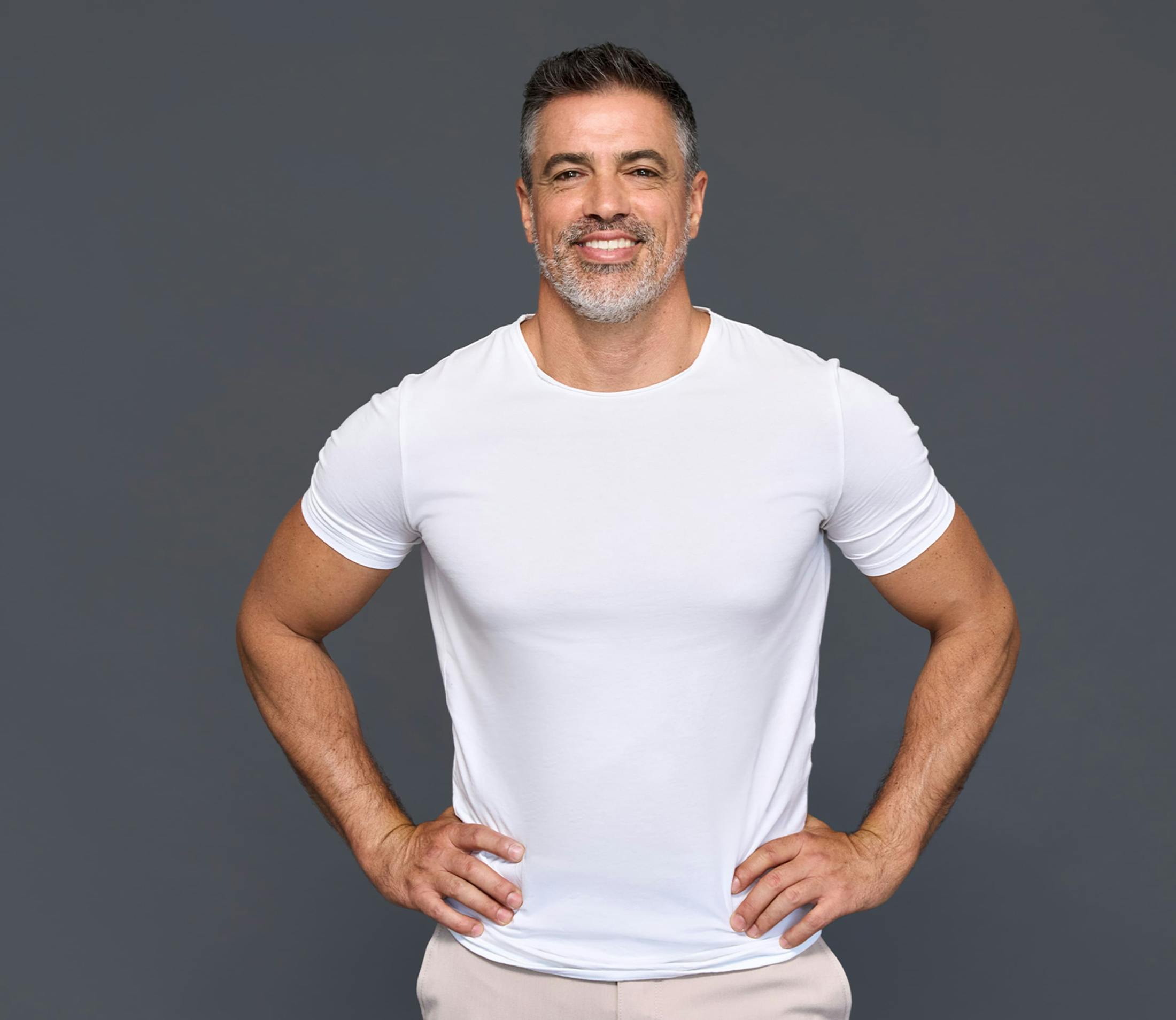 man smiling with his hands on his hips
