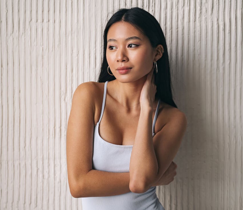 woman with her hand on her neck