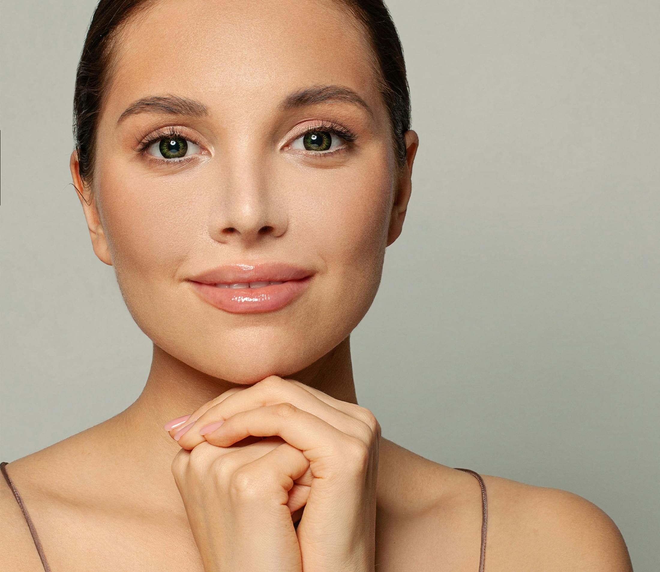 woman looking forward with head resting on clasped hands