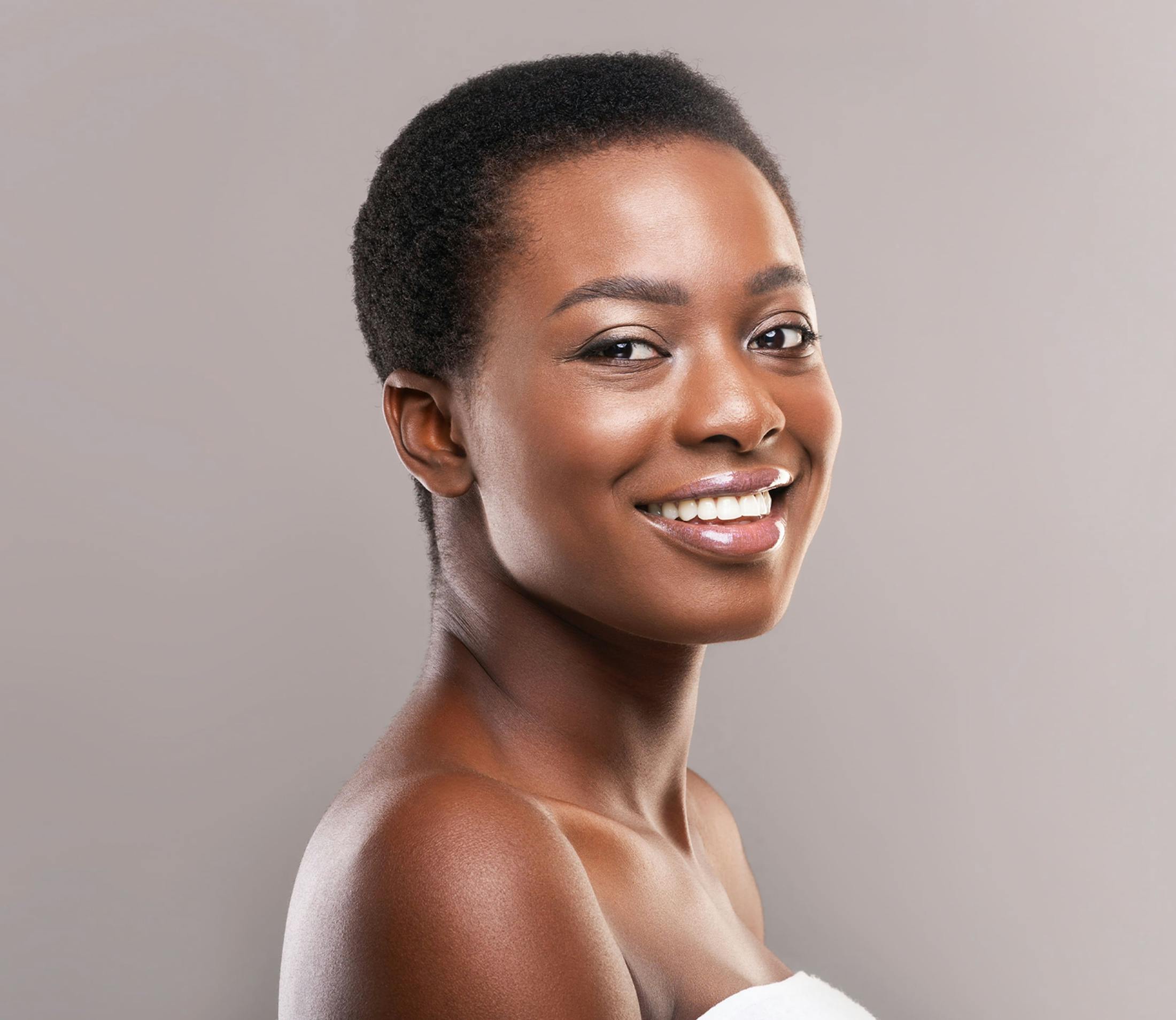 woman with dark short hair smiles looking over her shoulder