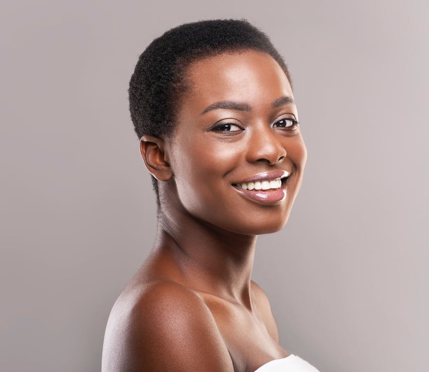 woman with dark short hair smiles looking over her shoulder