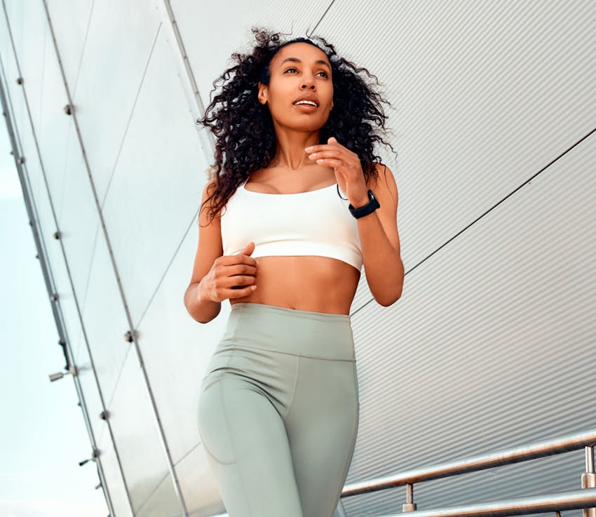woman in green athletic pants running