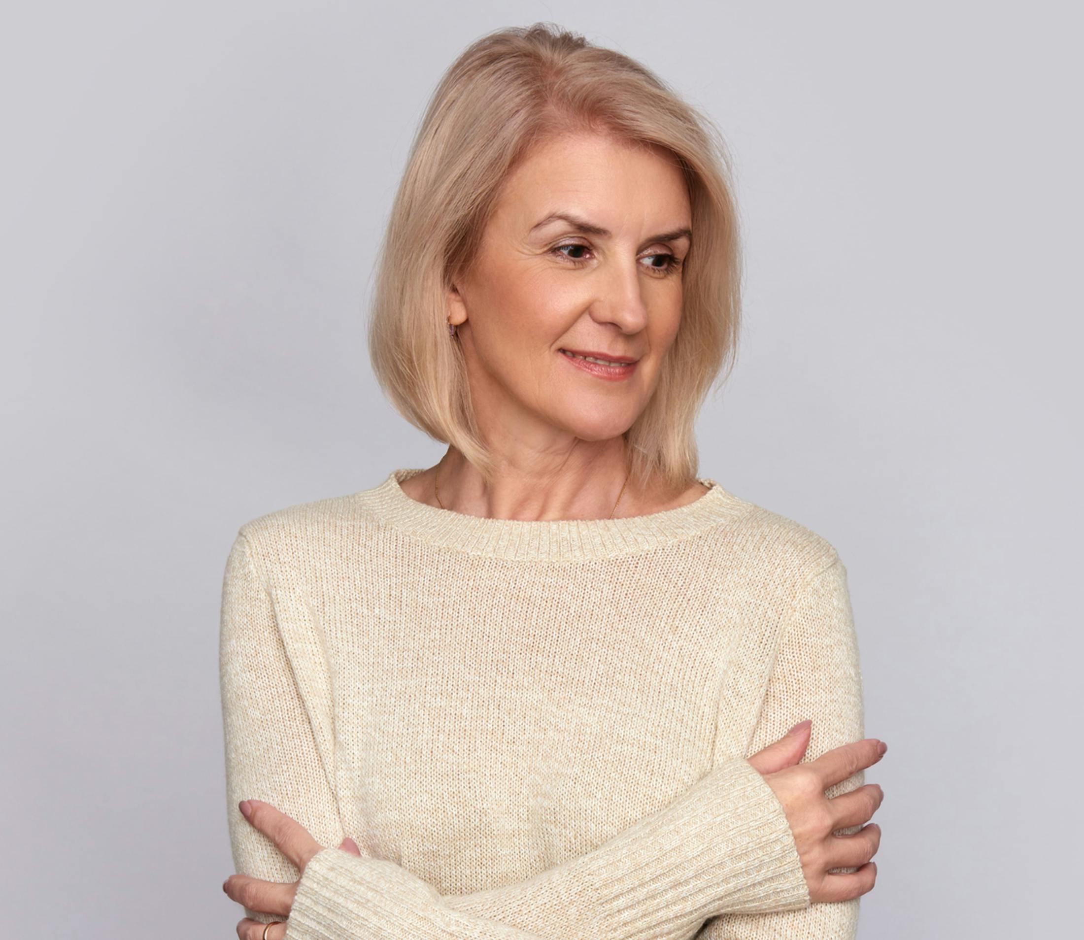 woman in white sweater with her hands on her biceps
