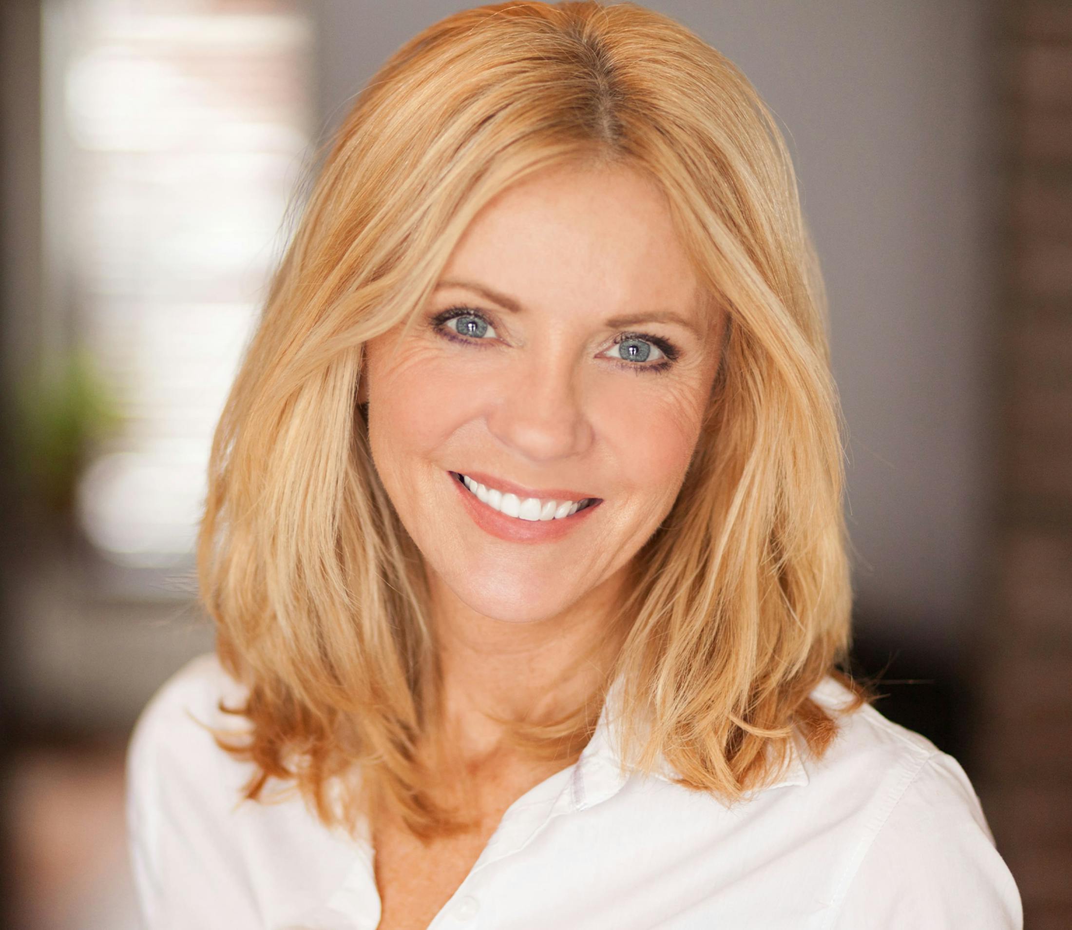woman in white shirt with hair in blonde straight bob