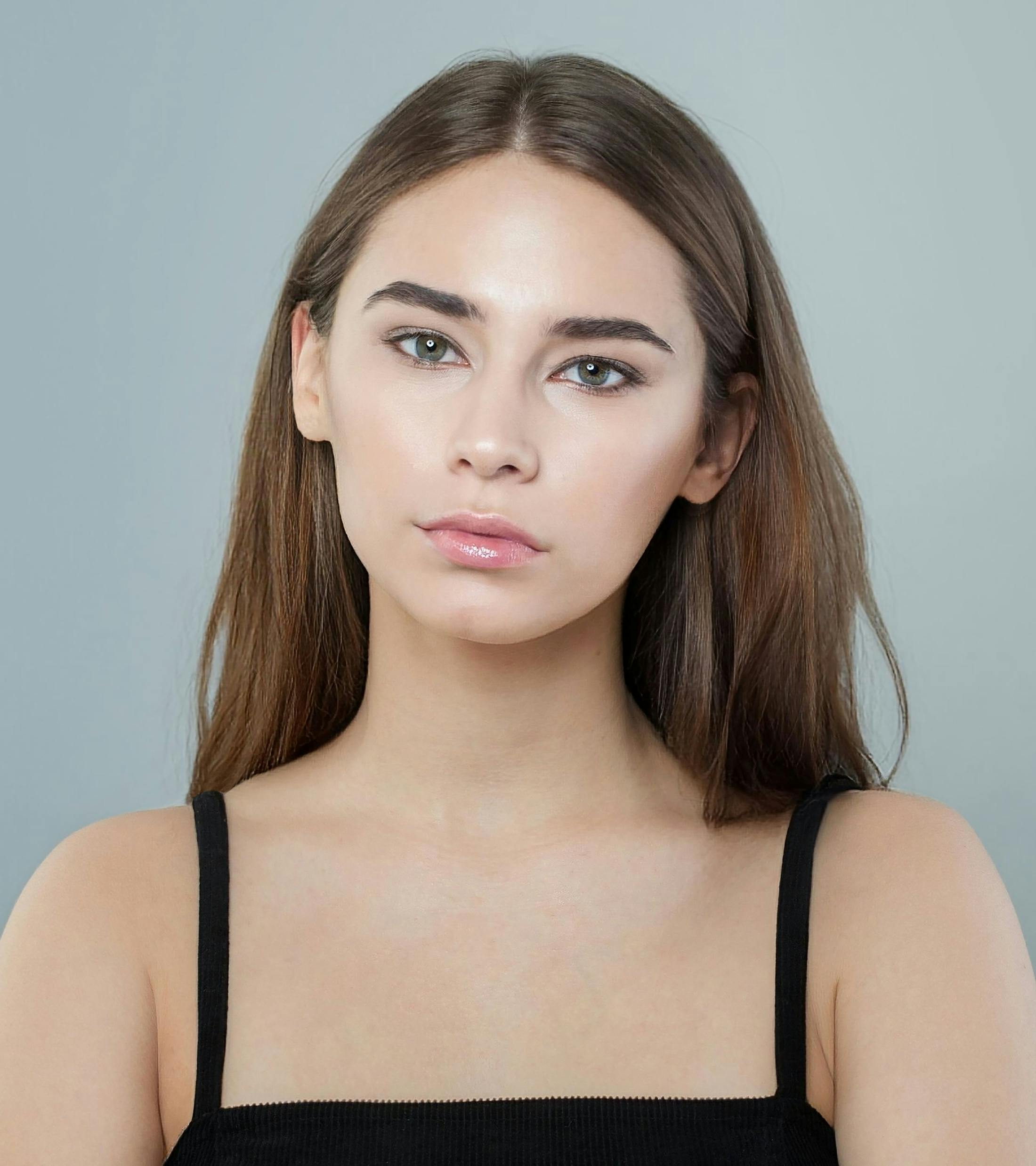 woman with hair behind shoulders looks forward