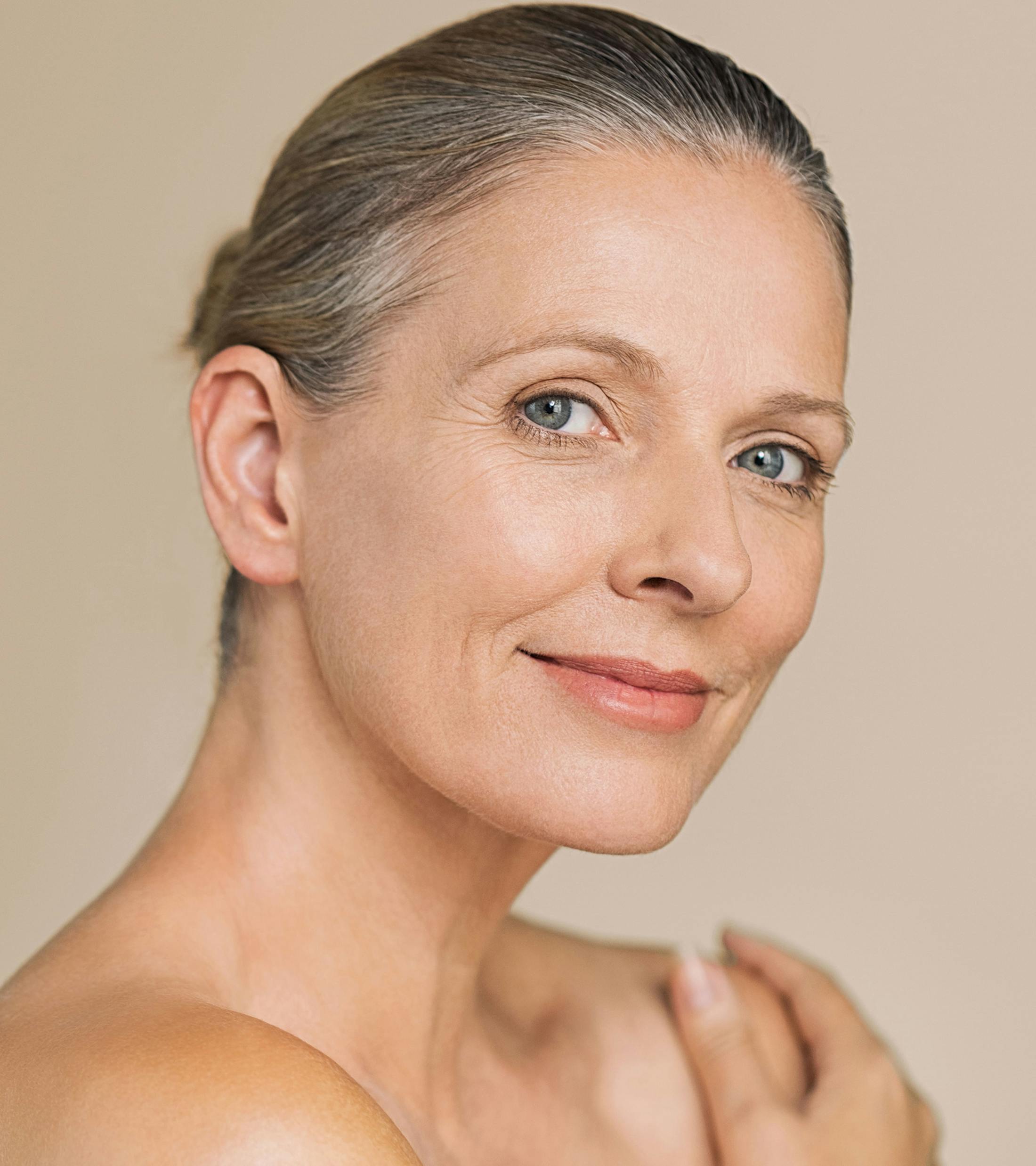 woman holding her shoulder while looking over her other shoulder