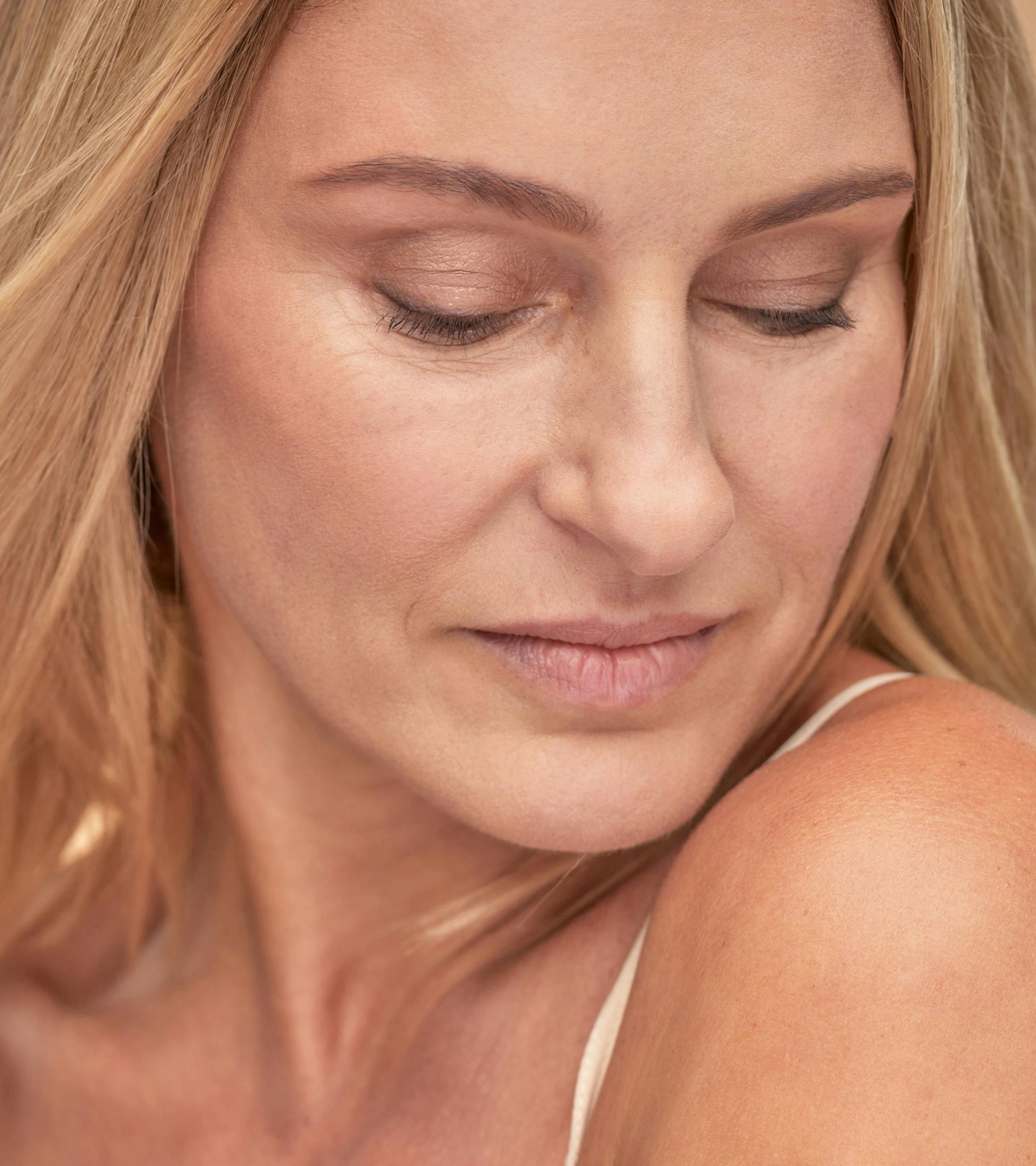 woman with blond hair looking towards her shoulder