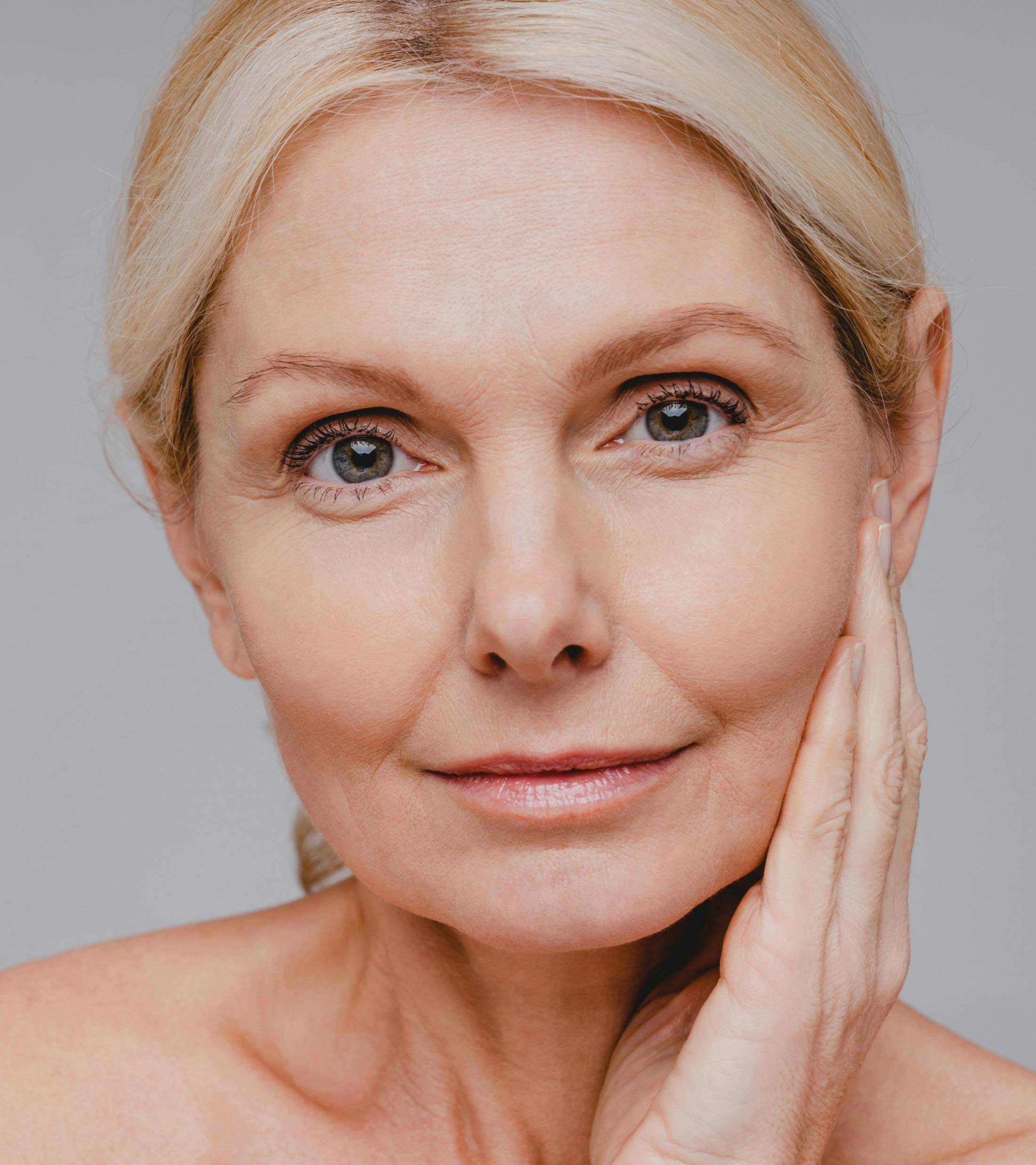 close up on woman's face while she touching the side of her face with her hand