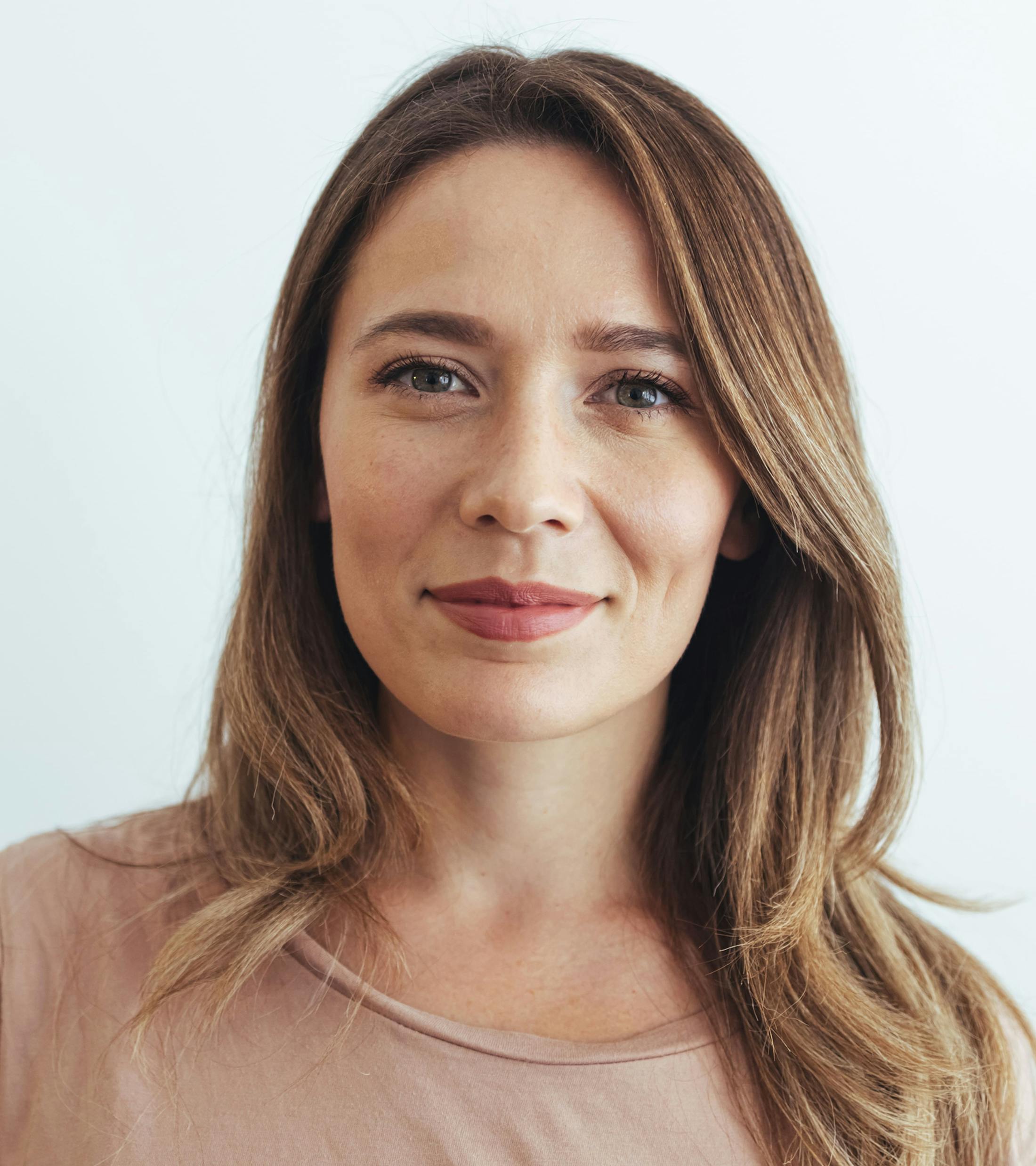 woman with dark straight hair smiling looking forward
