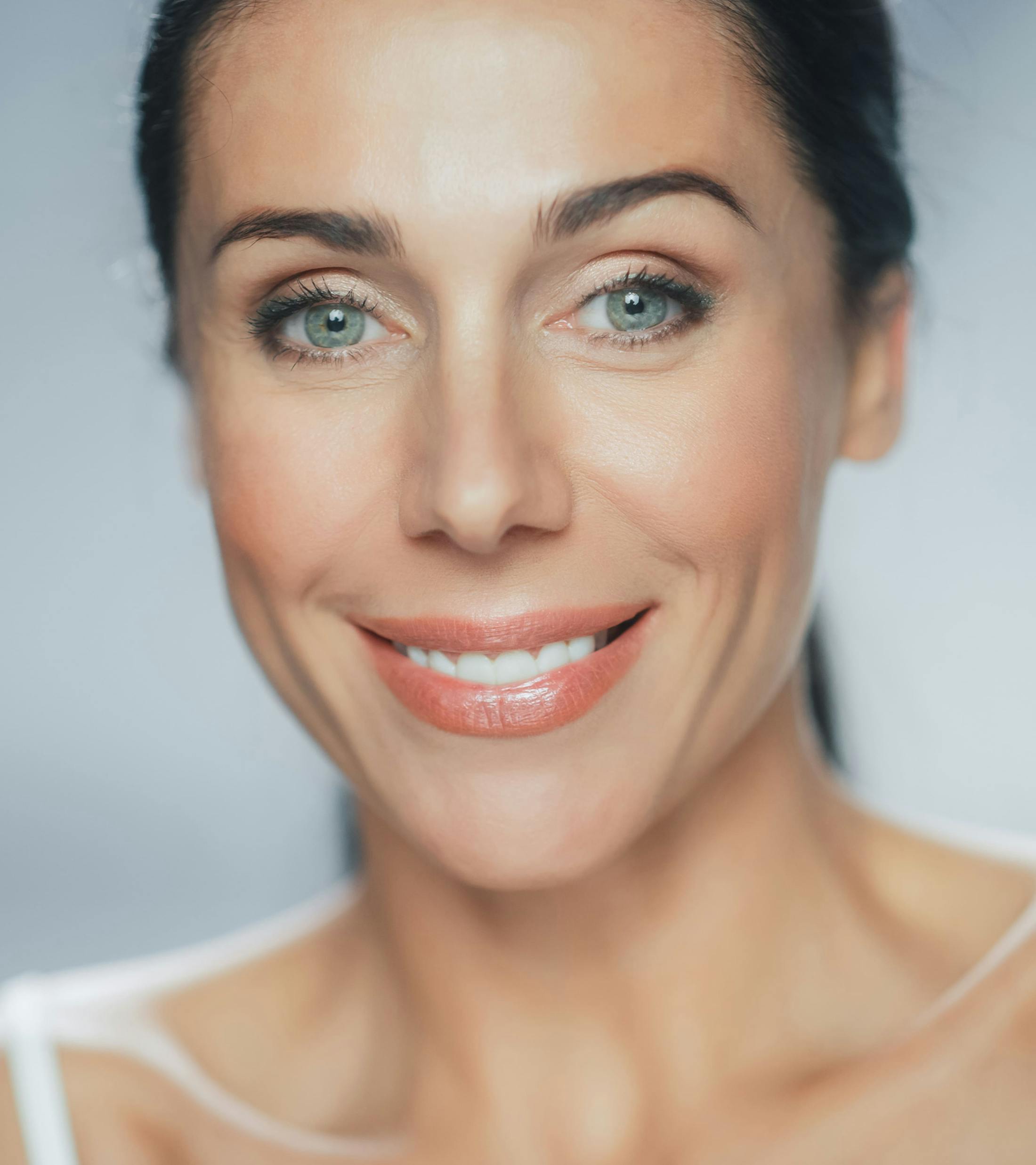 woman smiling forward with greenish blue eyes