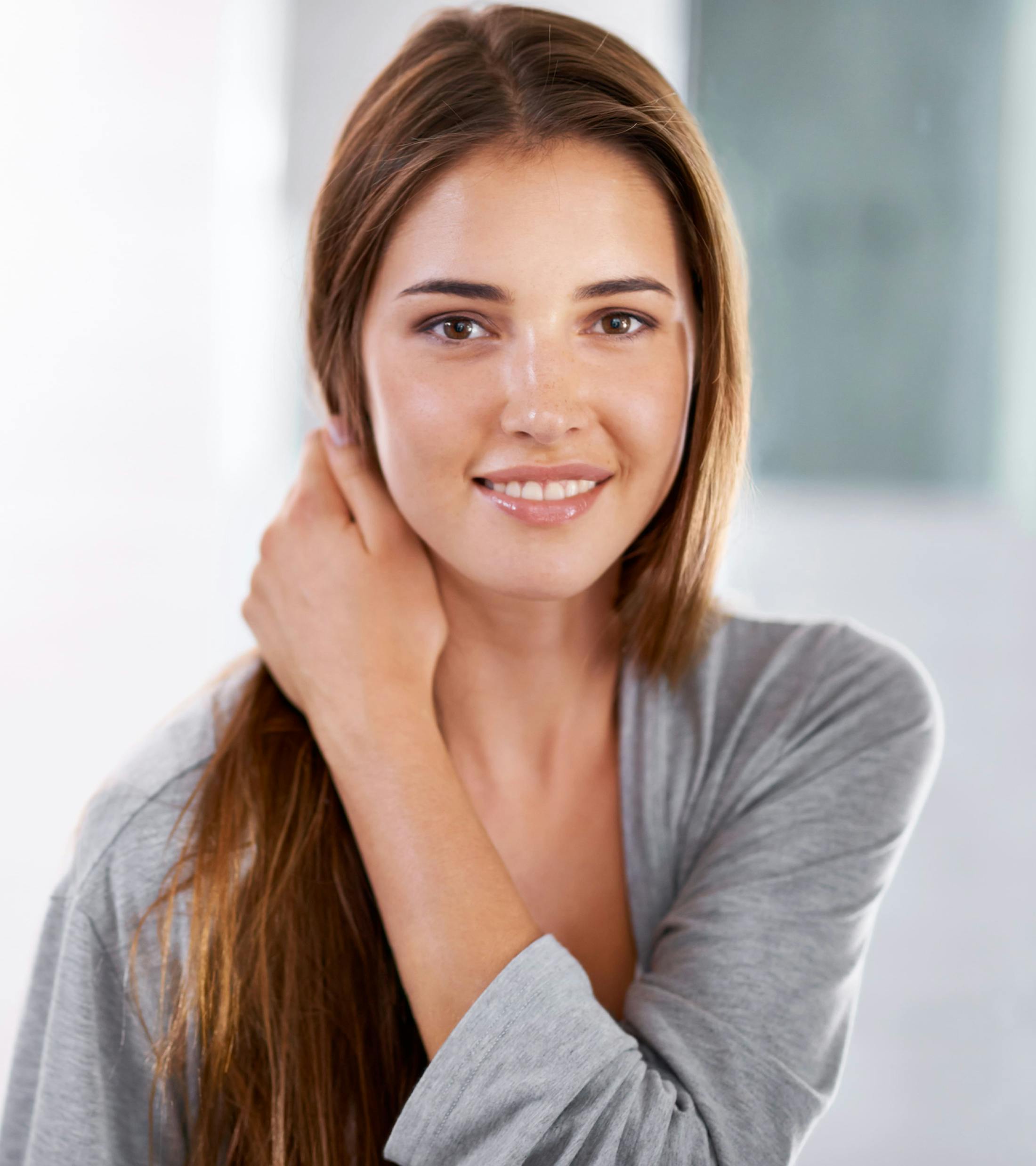 woman smiling and moving her hair back