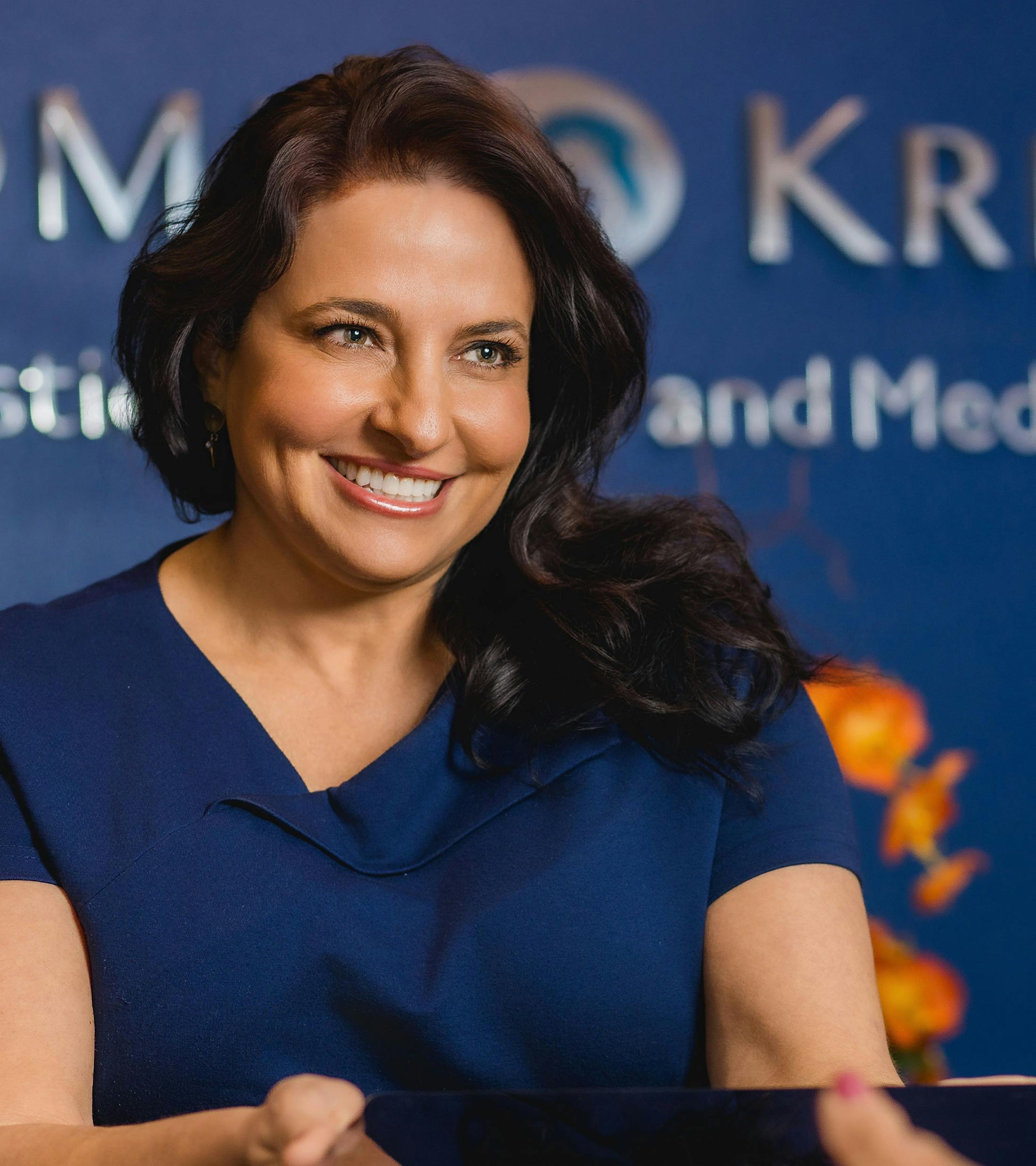 woman smiling in blue shirt in Holcomb & Kreithen lobby