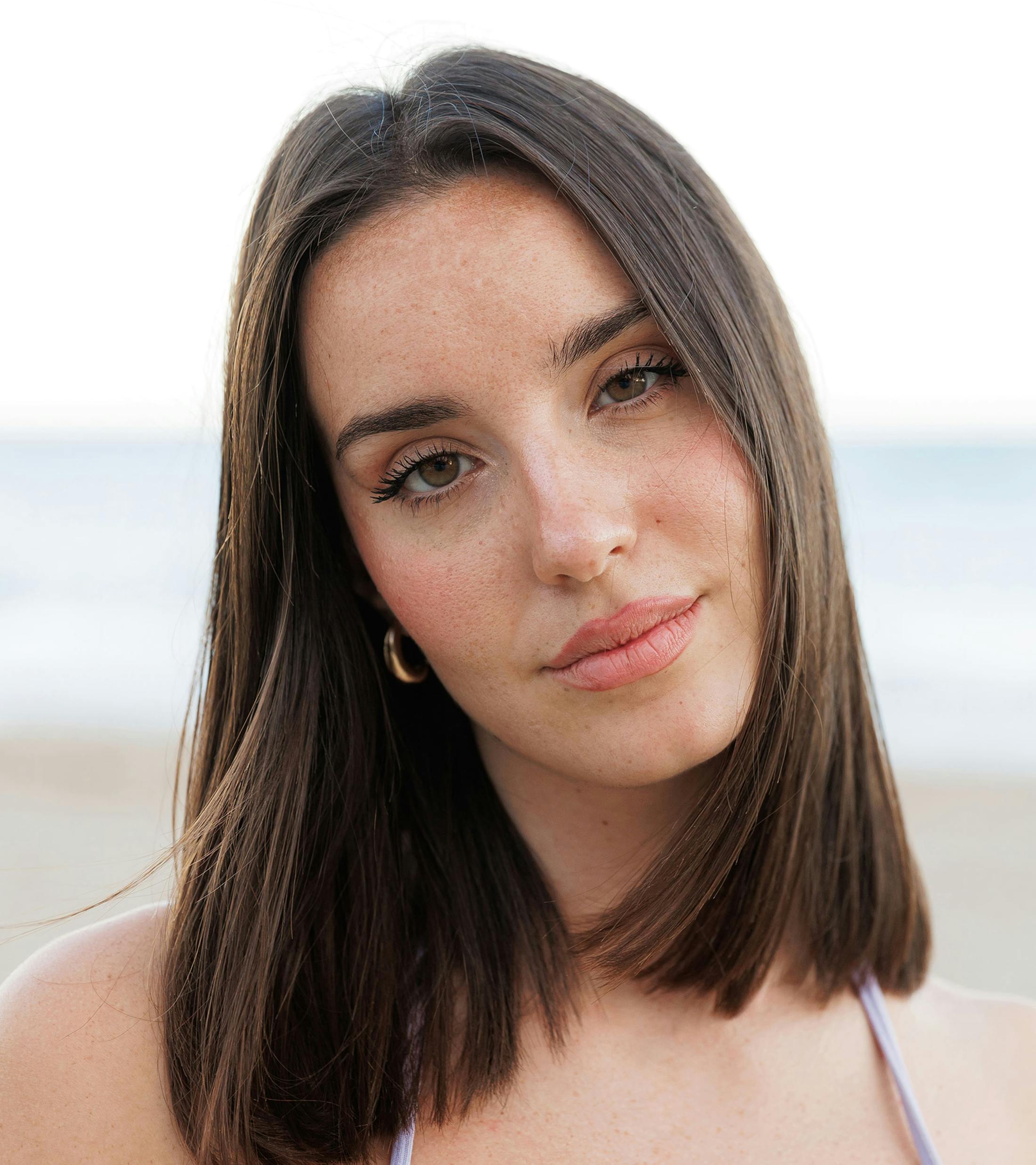 woman with brown shoulder length hair tilting her head to the side