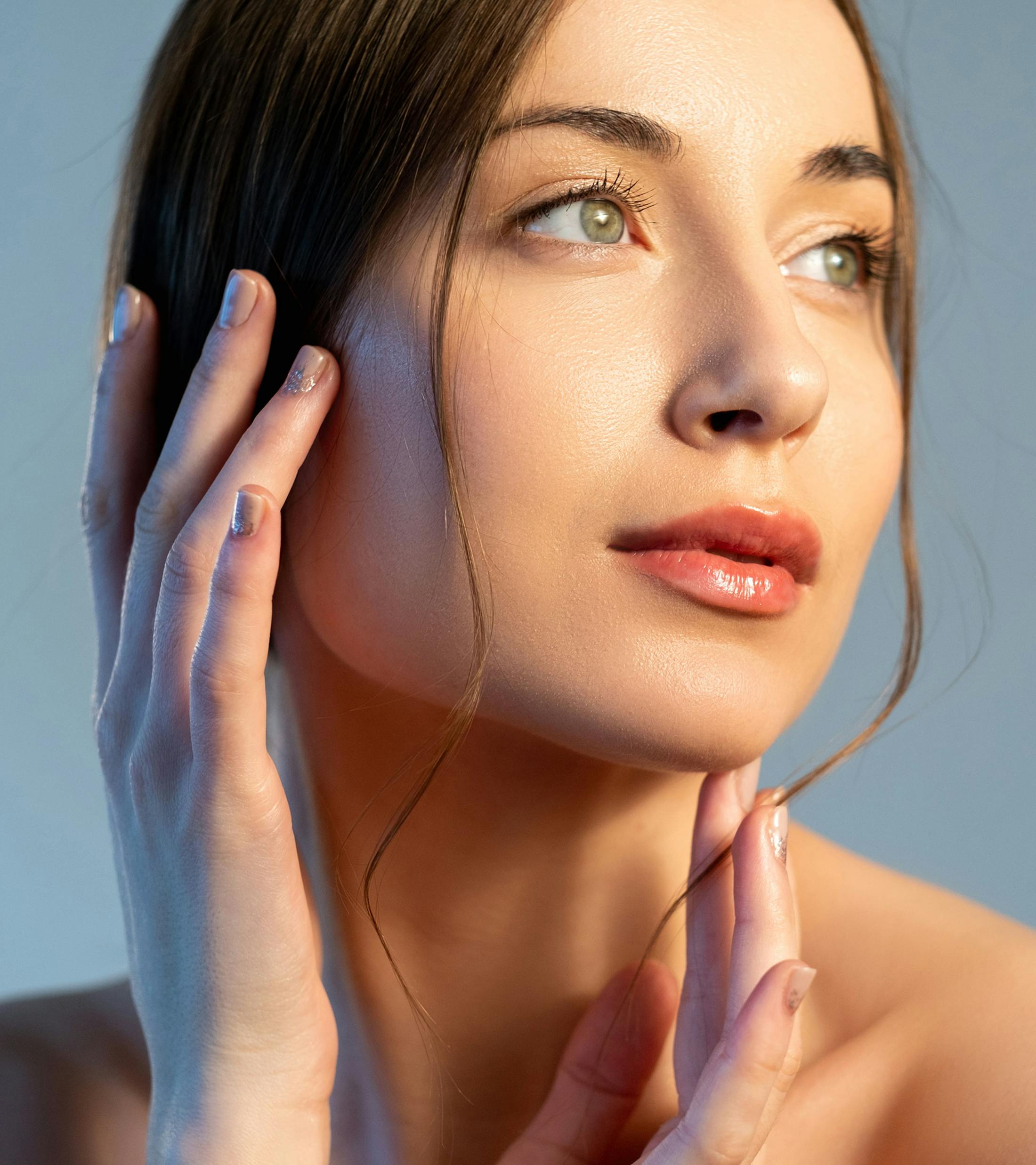 woman looking to the side with her hand on her temple and chin