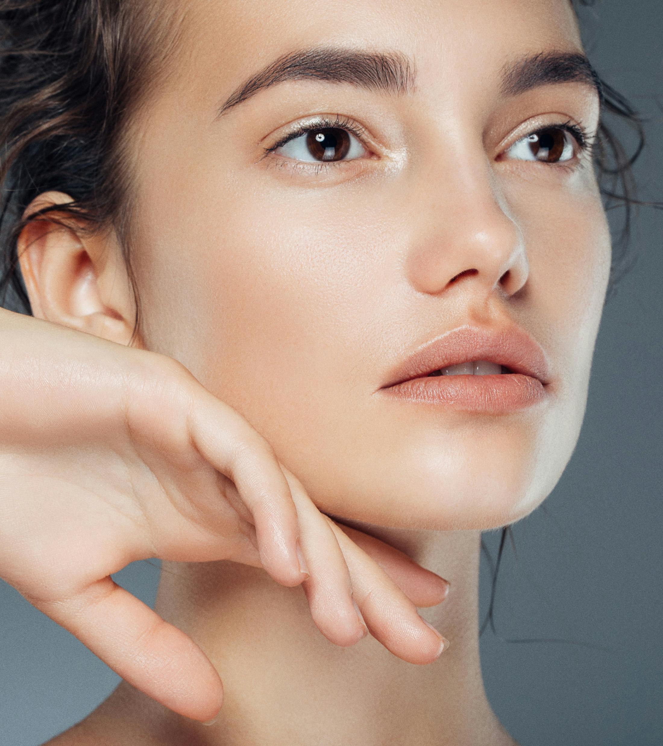 woman brushing her jaw with backside of hand