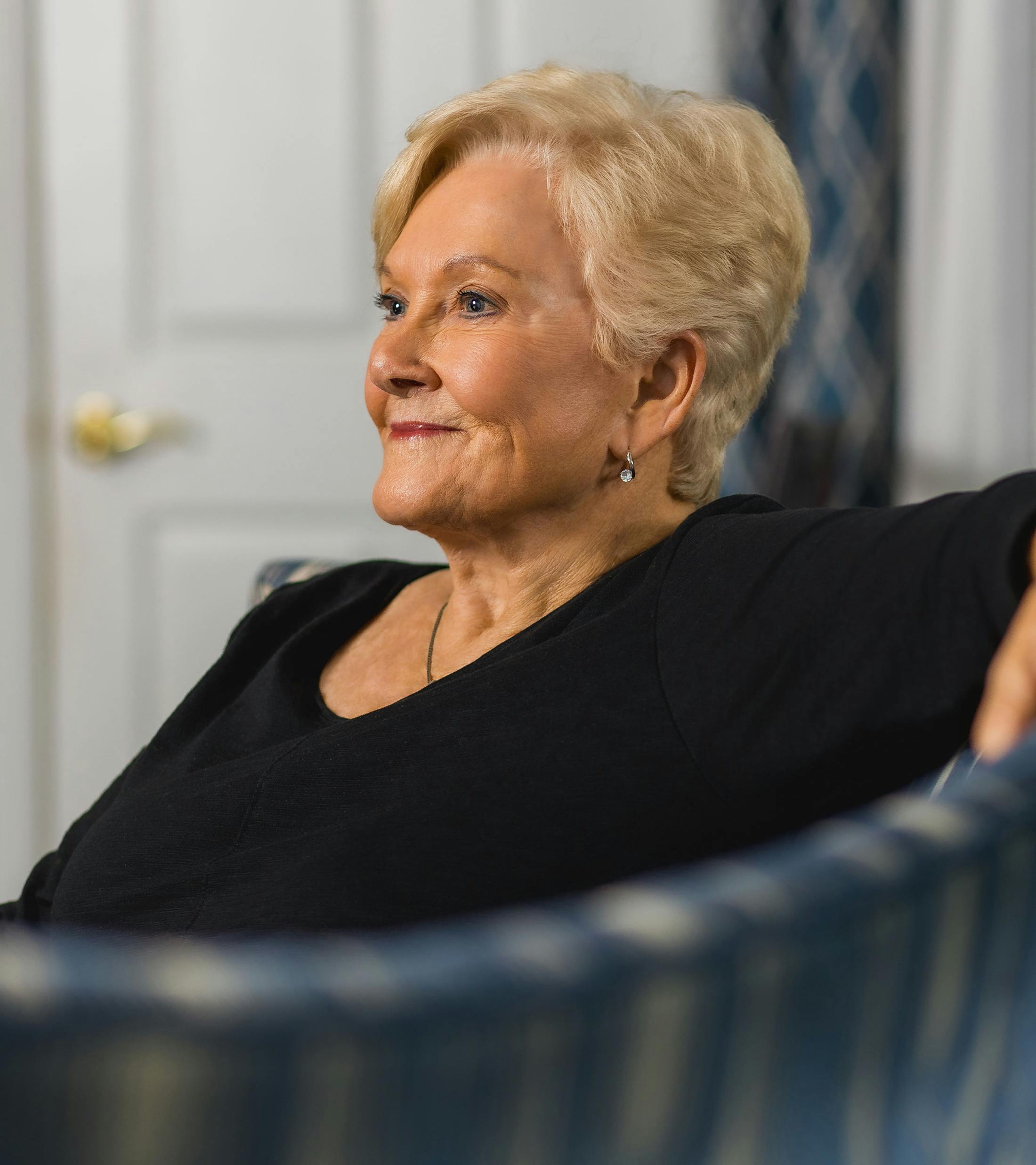 older woman with short hair sitting on couch