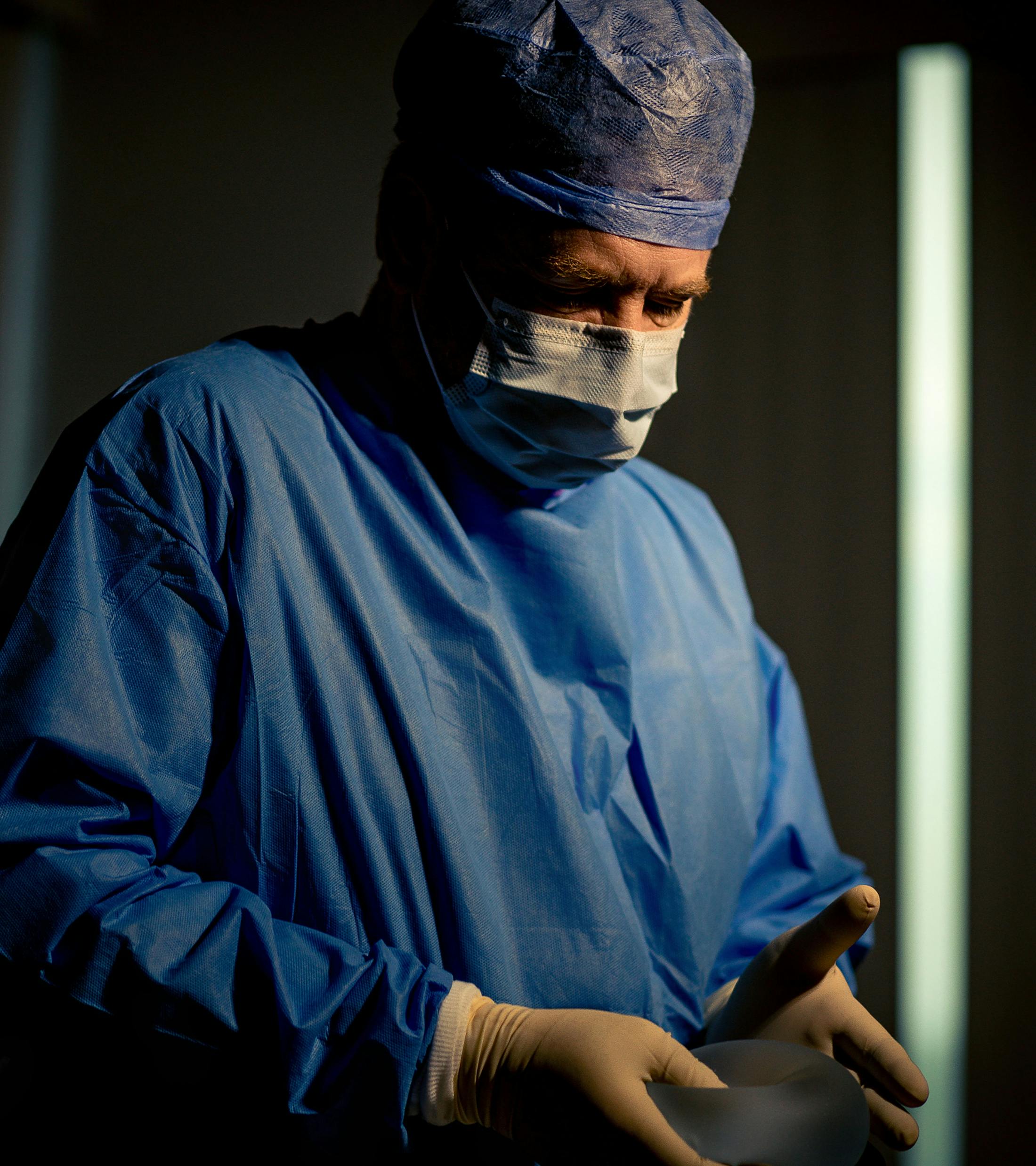 Dr. Kreithen holding implant in professional attire