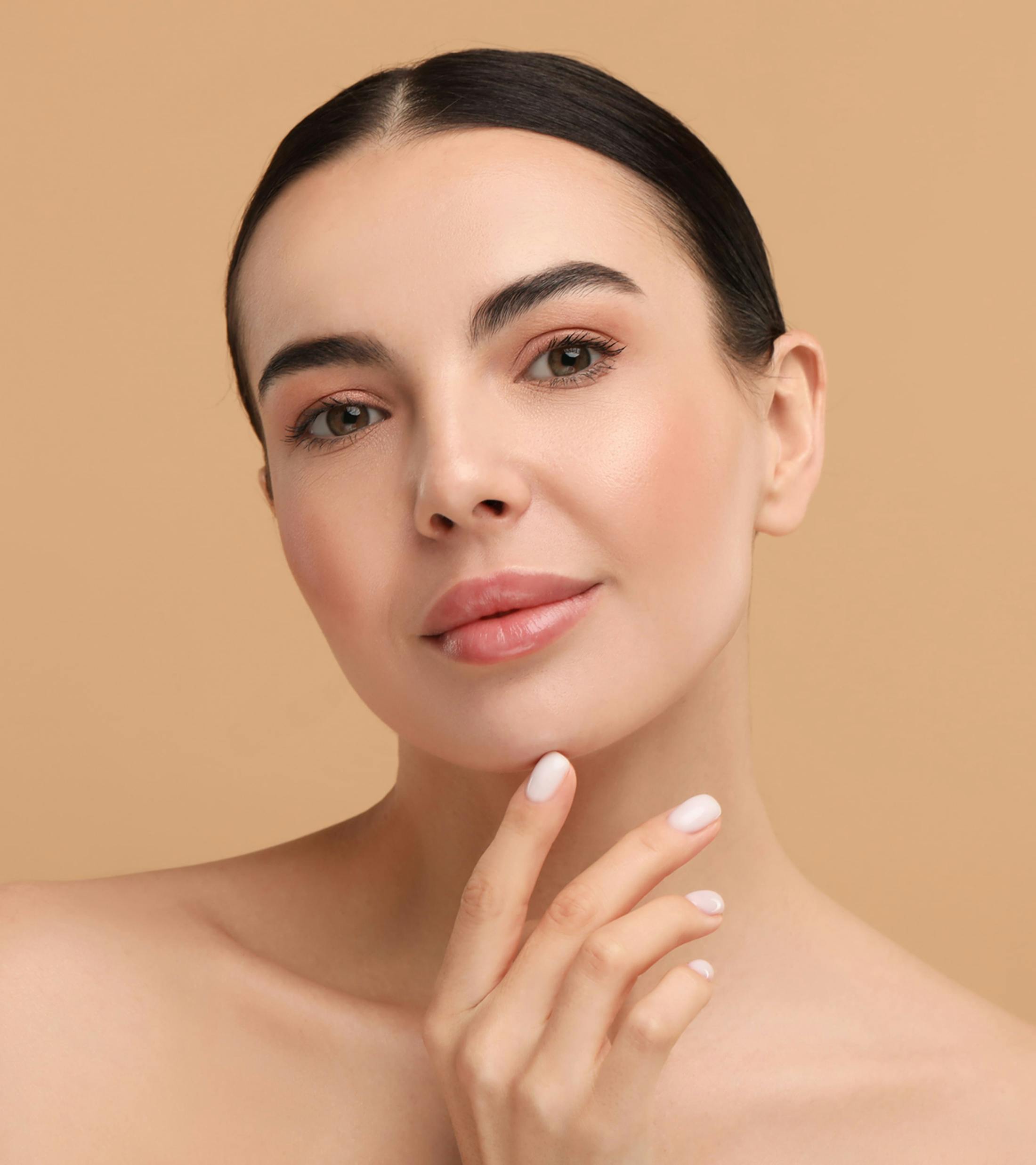 woman with a finger on her chin looking forward