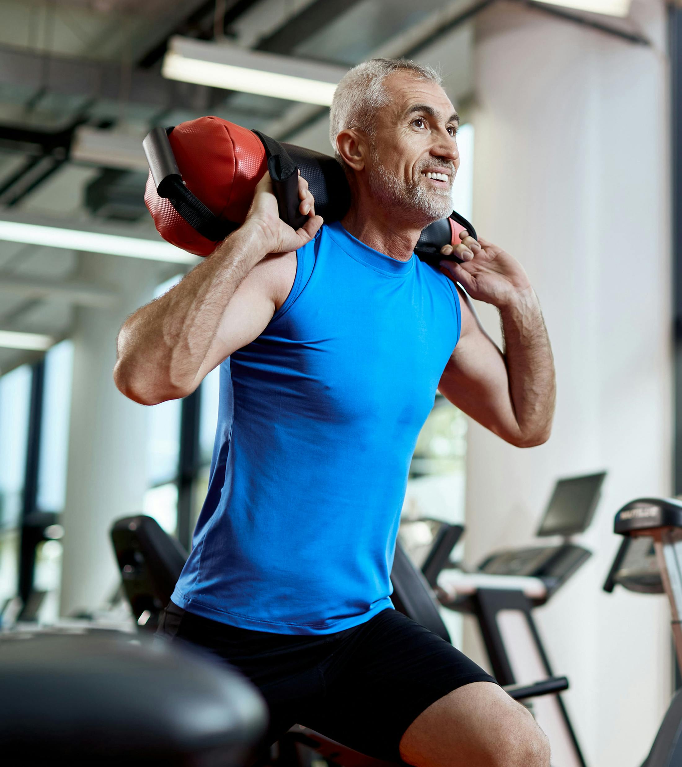 man in athletic attire lunging with weights on his shoulders