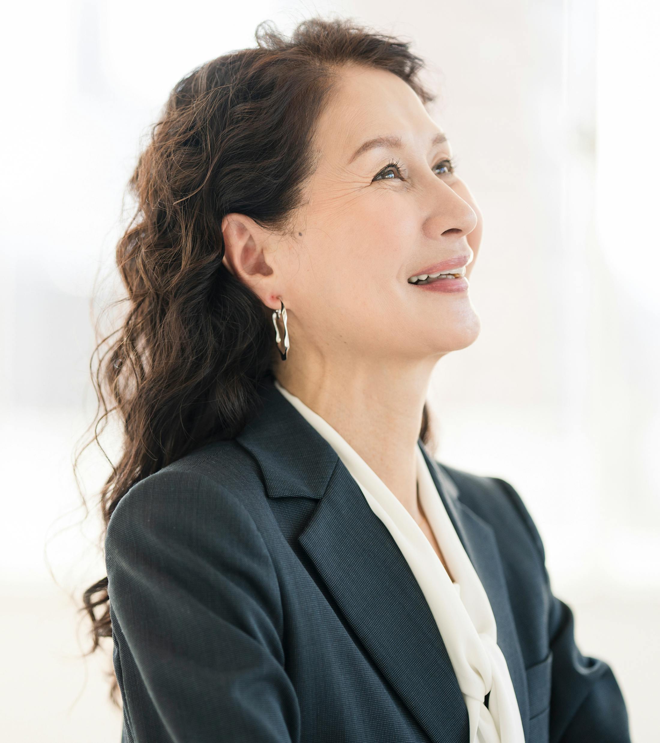woman with curly hair wearing a suit jacket
